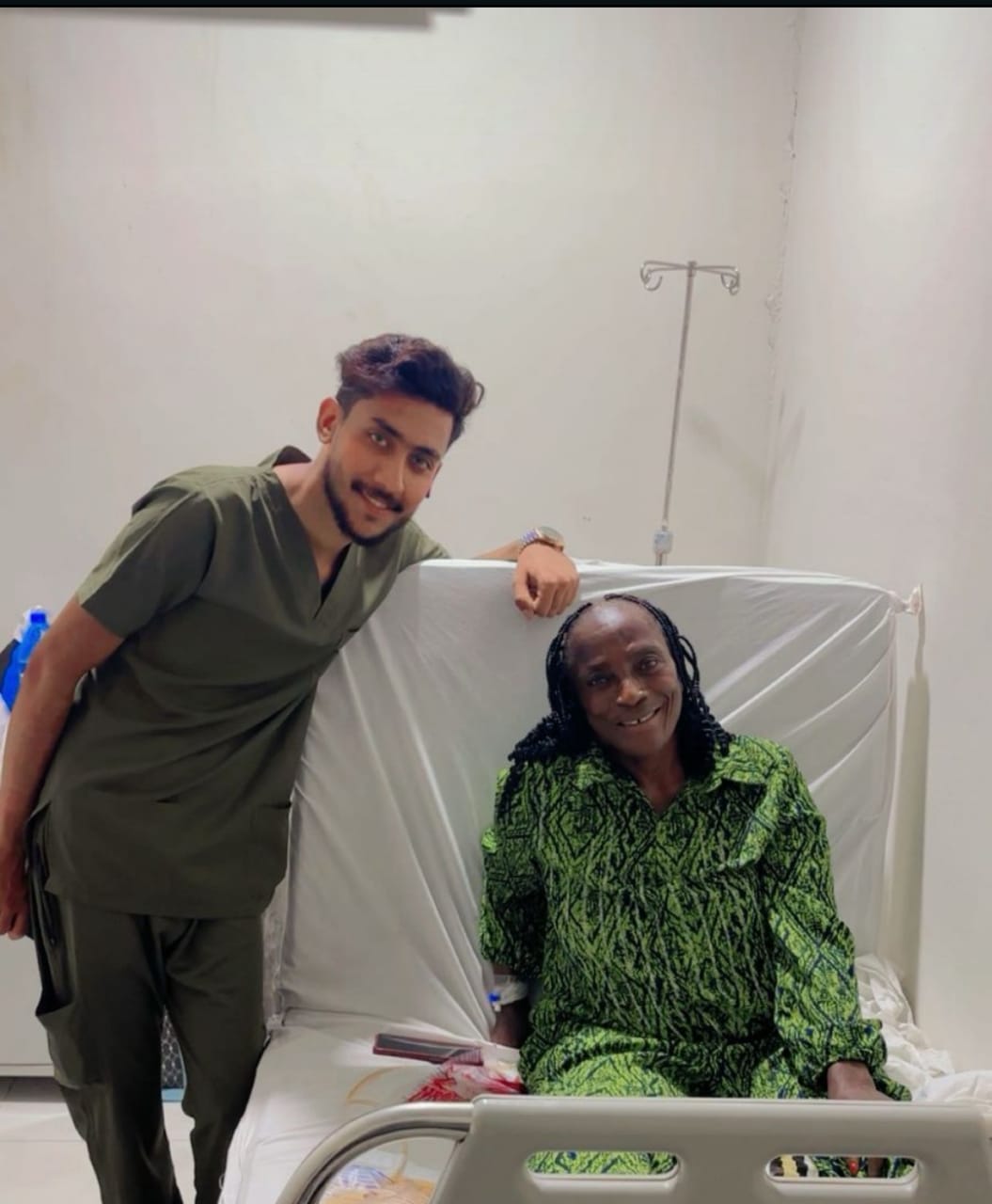 Patient resting in hospital bed with team